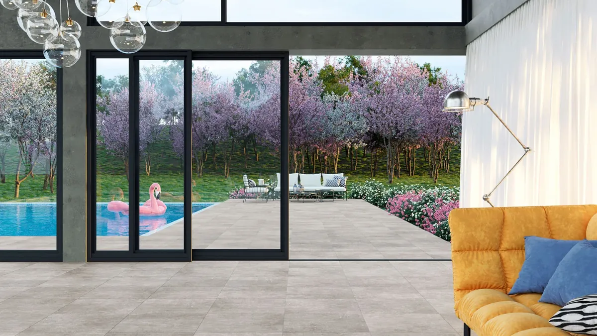 Indoor porcelain floor flowing seamlessly through open doors onto a matching outdoor floor